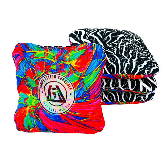 Two cornhole bags, one tie-dye and one zebra pattern, on a white background.